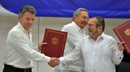 El presidente de Colombia, Juan Manuel Santos, estrecha la mano al líder de las FARC, Timoleon Jiménez, conocido como Timochenko