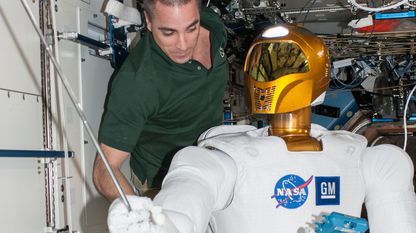 O astronauta da NASA Chris Cassidy traballa na estación espacial internacional co Robonaut 2